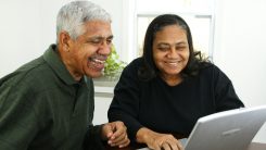 Two older adults looking at a computer
